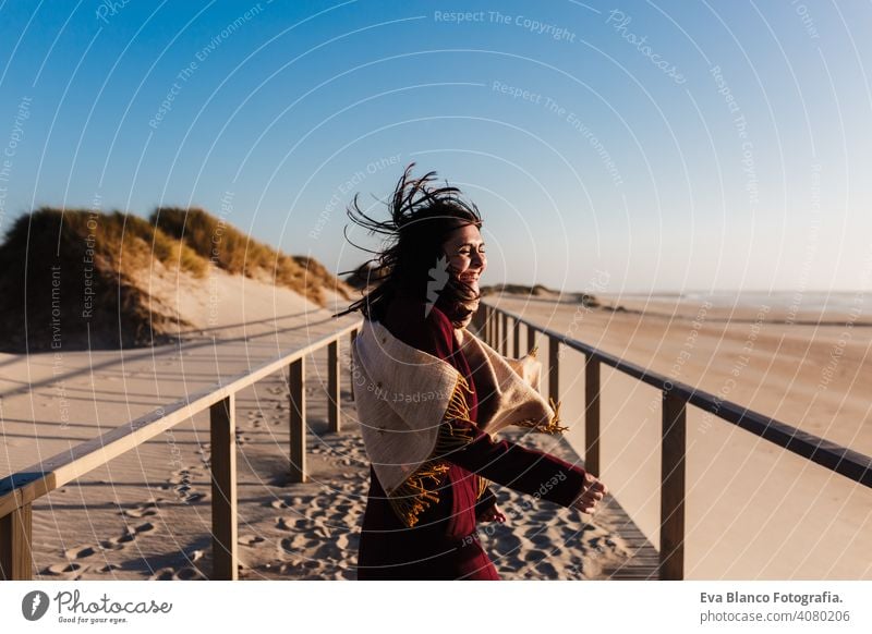 happy woman having fun at the beach on a windy day at sunset. Holidays and fun concept running laughing happiness relax caucasian vacation holidays runway