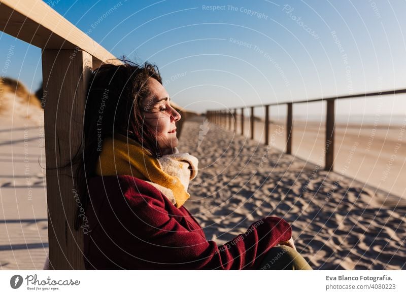 young caucasian woman with eyes closed relaxing at the beach at sunset. Holidays and relaxation concept vacation holidays runway passage attractive pretty