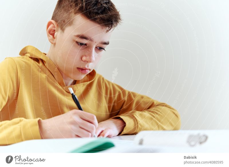 Teenage boy write homework at home. Education concept school writing studying education book person student people childhood caucasian desk young learning