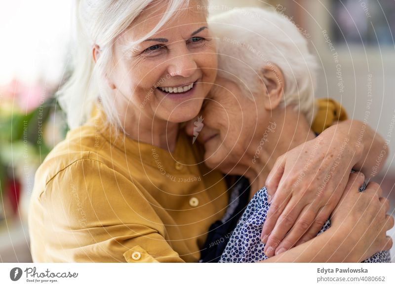 Woman hugging her elderly mother smiling happy enjoying positivity vitality confidence people woman senior mature casual female Caucasian home house old aging