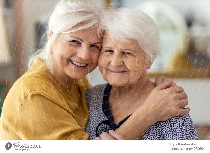 Woman hugging her elderly mother smiling happy enjoying positivity vitality confidence people woman senior mature casual female Caucasian home house old aging