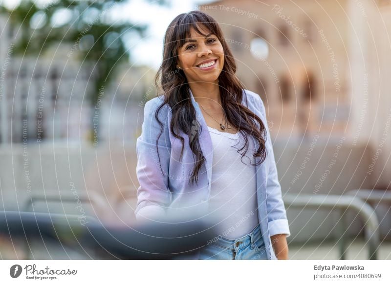 Attractive young woman smiling in the city hispanic latin summer fun joy happy happiness urban girl people female lifestyle outdoors adult business