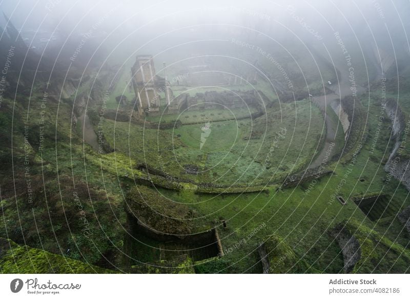 Majestic view of ancient ruins in fog mossy landscape volterra italy mist scenic nature beautiful green panoramic stone rocky field valley remnants haze castle