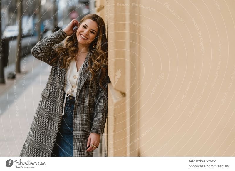 Woman leaning on wall on street woman building laughing city young cheerful style female urban trendy fun joke joy happy casual elegant exterior lady structure