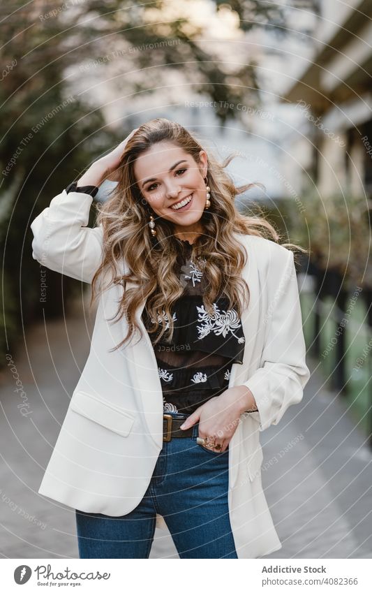 Charming lady posing on street woman city young urban lifestyle leisure sensual female denim trendy windy toothy joy elegant town casual gesture excited glad