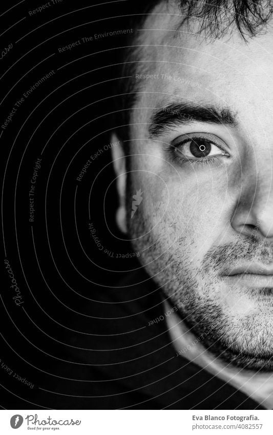 close up half side portrait of a young man. studio shot. led ring reflection in the eyes head white people male black dramatic person lifestyle closeup one