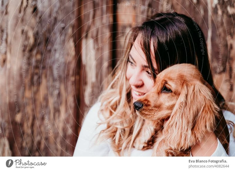 young woman and her cute puppy of cocker spaniel outdoors dog pet park sunny love hug smile back view kiss breed purebred beautiful blonde brown lifestyle