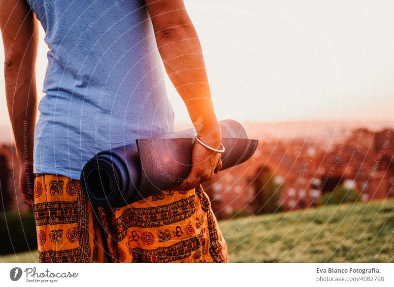 young man in a park ready to practice yoga sport. city background. healthy lifestyle. close up view concentration position people body meditation sunrise beauty