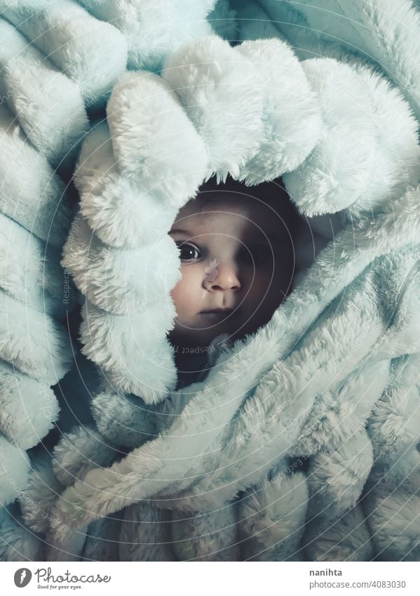 Little baby wrapped up with a warm green blanket portrait baby girl artistic winter cozy rug warm clothes home blue eyes lovely adorable babyhood childhood