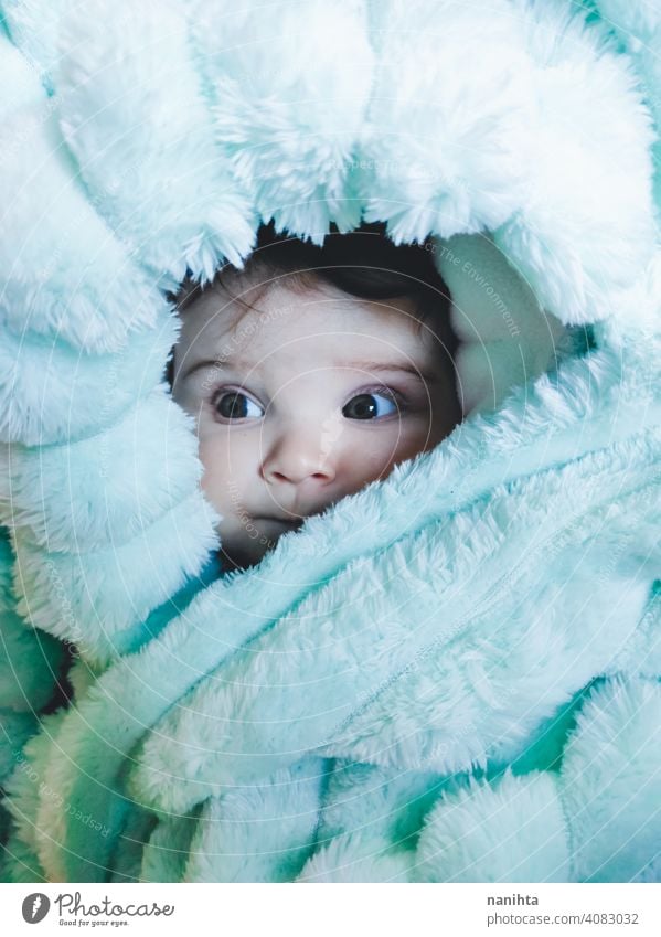 Little baby wrapped up with a warm green blanket portrait baby girl artistic winter cozy rug warm clothes home blue eyes lovely adorable babyhood childhood