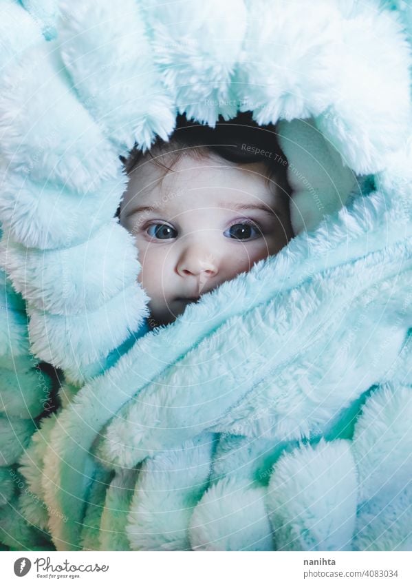 Little baby wrapped up with a warm green blanket portrait baby girl artistic winter cozy rug warm clothes home blue eyes lovely adorable babyhood childhood