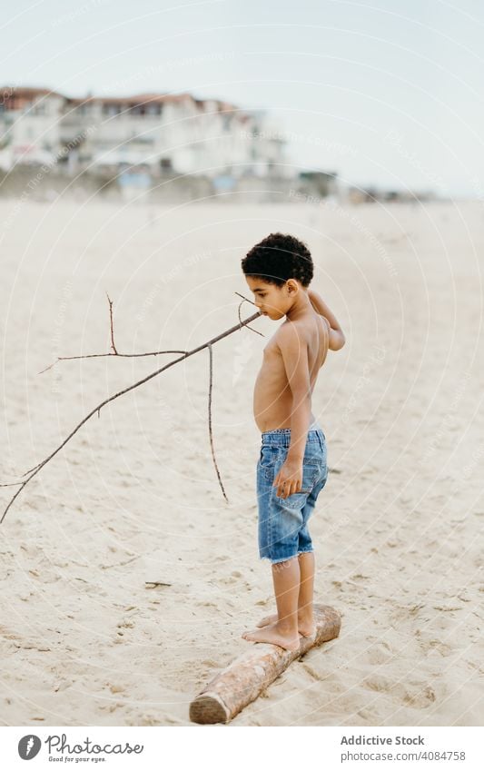 Anonymous black kid walking on log child legs sand summer beach barefoot little wet lifestyle leisure rest relax ethnic african american vacation shore coast