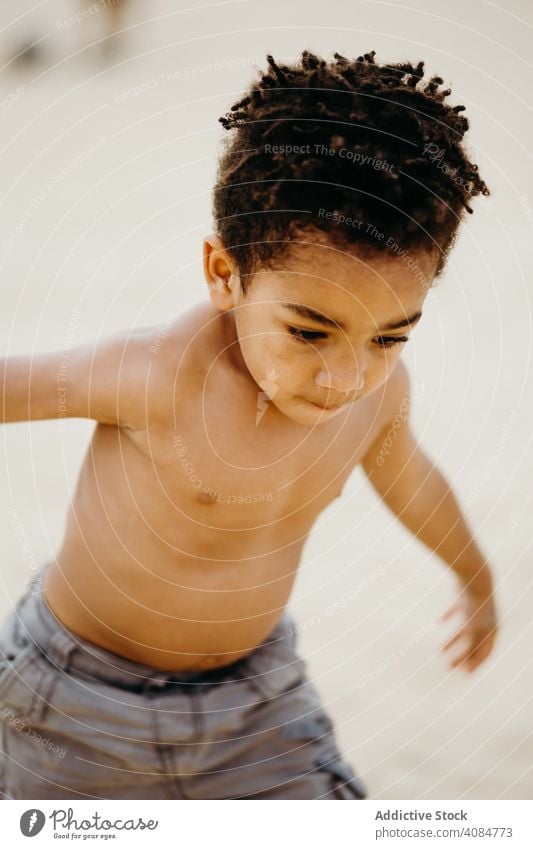 Black boy playing on beach sea fun summer water shirtless barefoot kid child siblings game happy weekend lifestyle leisure shore coast ocean wet joy cheerful