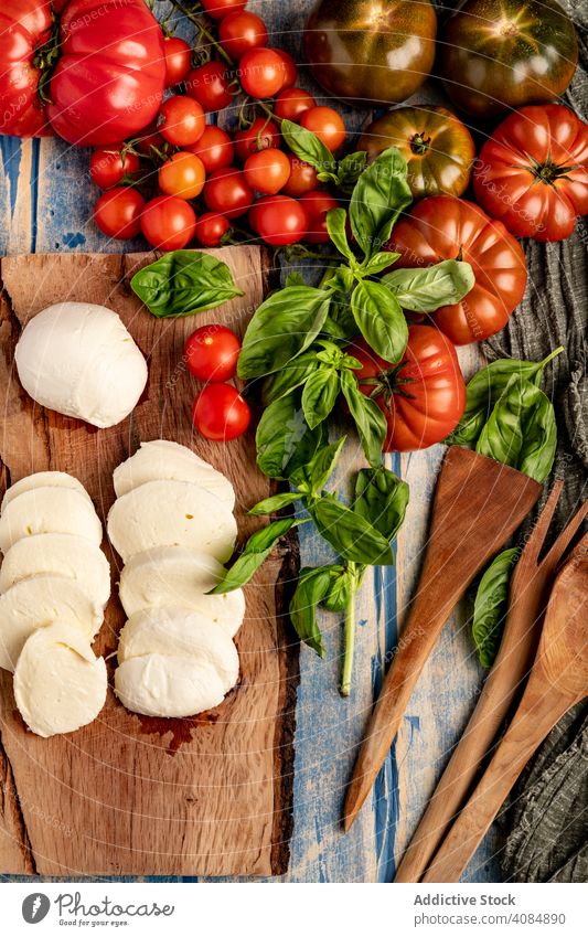 Salad ingredients on board and napkin tomatoes cheese basil salad mozzarella leaves fresh ripe food meal kitchen italian cuisine healthy lunch gourmet snack