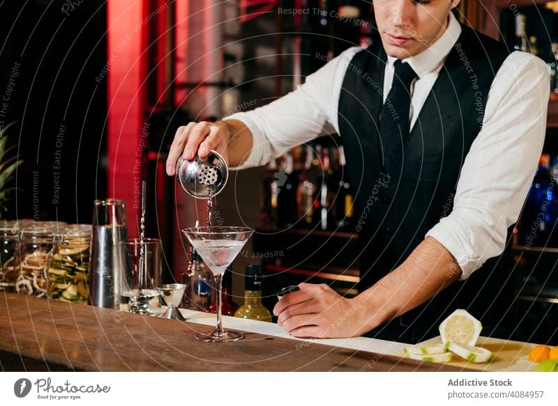 Barman working making drinks barman pineapple glass bartender caucasian pouring cocktail tie elegant celebration shaker hospitality luxury preparing party