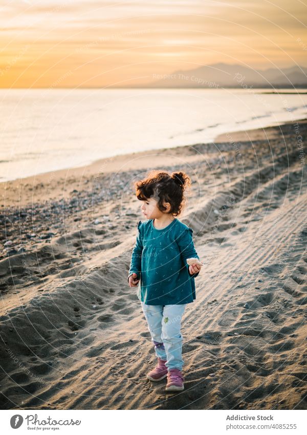 little girl looking at sea beach view freedom adorable summer ocean standing kids sand water travel white beautiful child vacation blue caucasian outdoor young