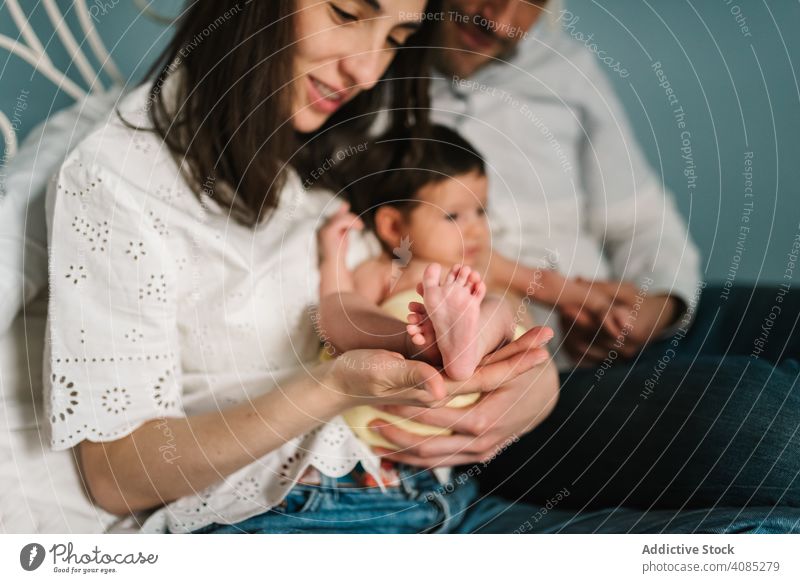 Parents hugging baby on bed couple parents home together family tender care love mother father man woman kid child infant newborn joy innocence lifestyle