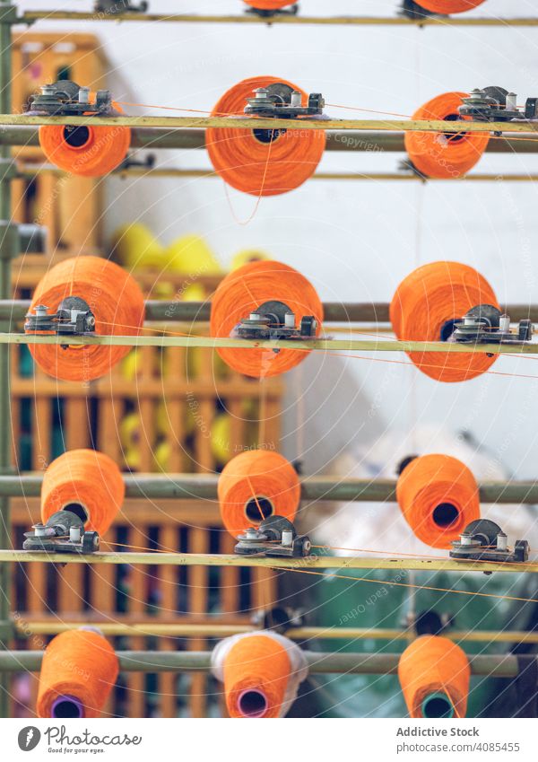 Spools of thread on weaver loom spools industry factory fiber cotton textile fabric machine manufacturing string craft yarn cloth orange bright color material