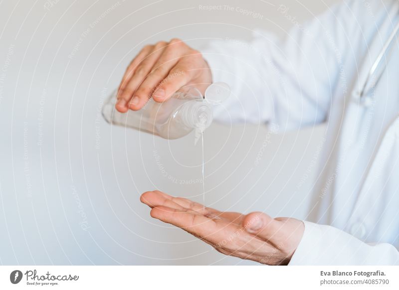 caucasian doctor wearing protective mask and gloves indoors. Using an alcohol gel or antibacterial disinfectant. Hygiene and corona virus concept man