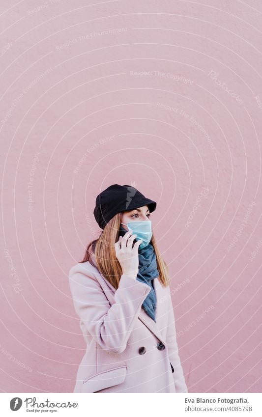 caucasian woman in the street wearing protective mask and using mobile phone. corona virus concept outdoors technology internet public adult infection space