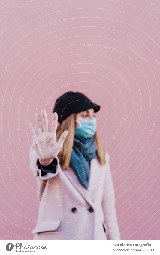 caucasian woman in the street wearing protective mask and using mobile phone. corona virus concept outdoors technology internet public adult infection space