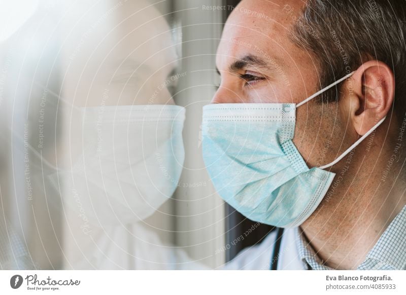 portrait of doctor man by the window wearing protective mask and gloves indoors. Corona virus concept professional corona virus hospital working infection