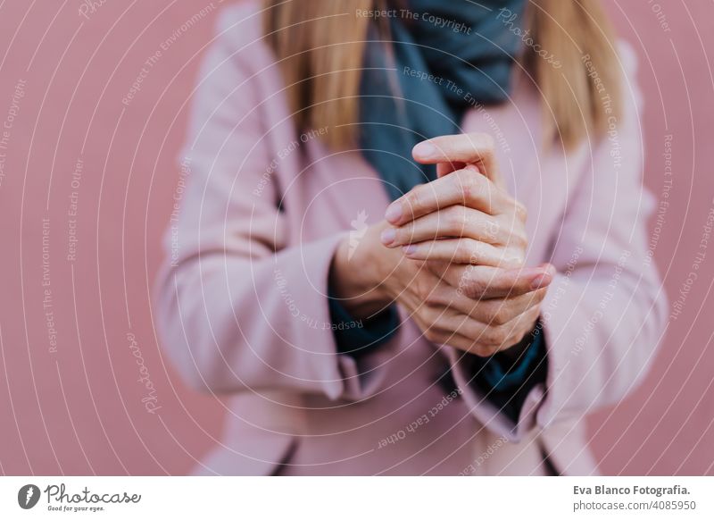 caucasian woman in the street using an alcohol gel or antibacterial disinfectant on hands. Hygiene and corona virus concept soap mask outdoors public adult