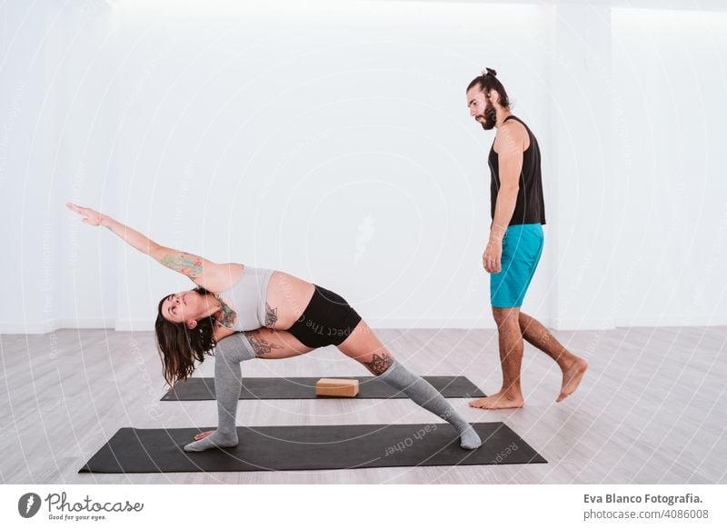 young man and woman practicing yoga sport at the gym. Healthy lifestyle boy health healthy indoors studio white hispanic sportive power professional male person