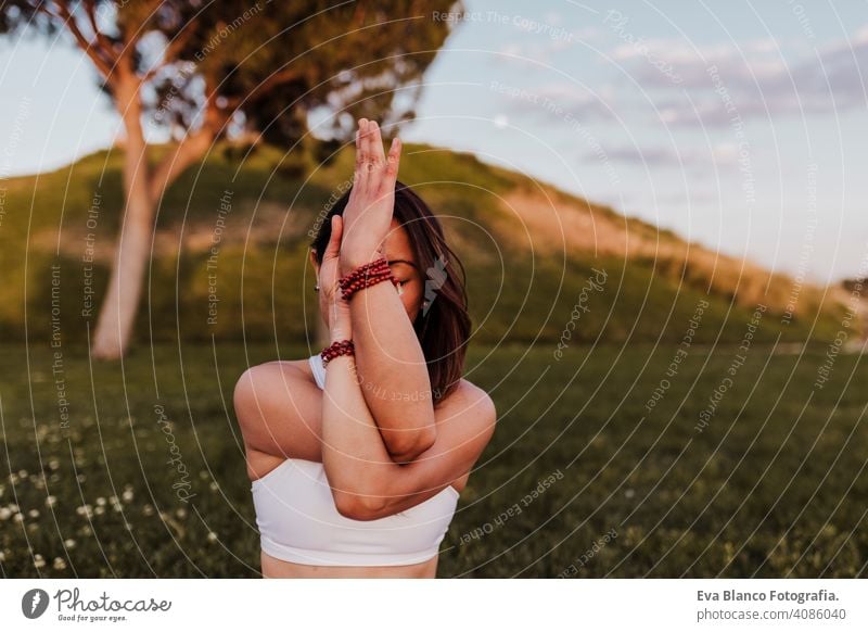 young beautiful asian woman doing yoga in a park at sunset. Yoga and healthy lifestyle concept. summer happy enjoyment sport sportive relax relaxation field