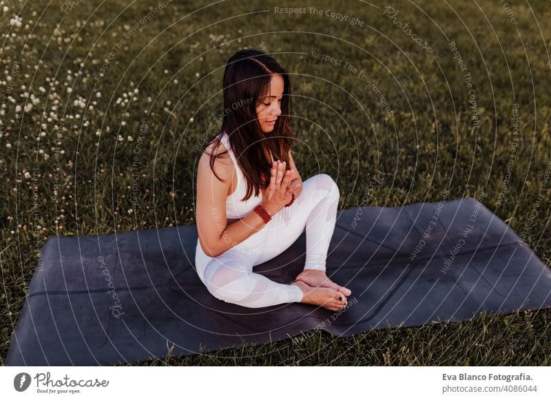 young beautiful asian woman doing yoga in a park at sunset. Yoga and healthy lifestyle concept summer happy enjoyment sport sportive relax relaxation field