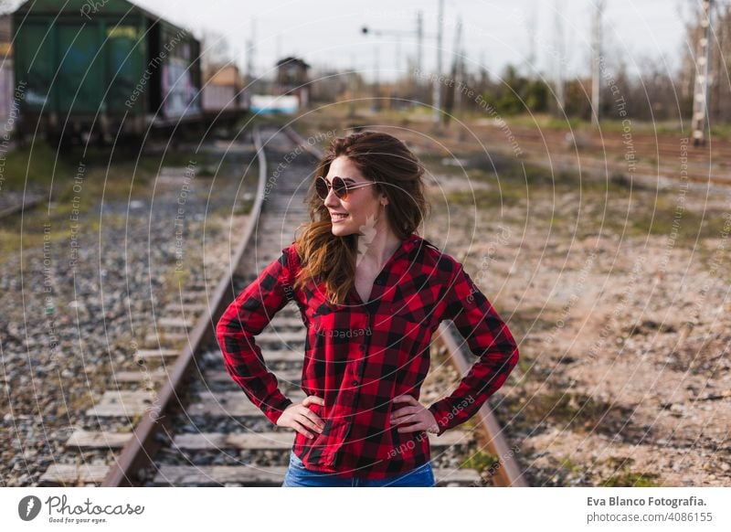 young beautiful woman wearing casual clothes, walking by the railway and smiling. Outdoors lifestyle. Travel concept. city outdoor femininity fashion attractive