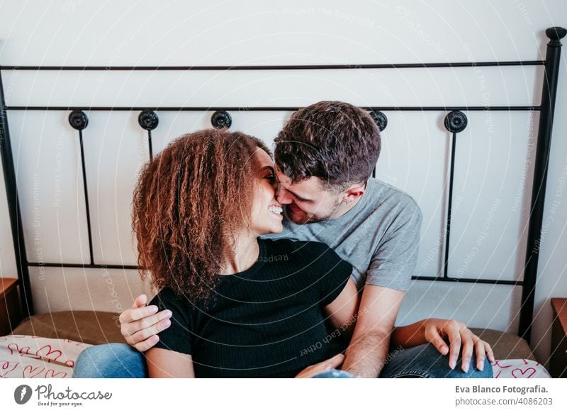 happy couple in love at home. Afro american woman and caucasian man. ethnic love concept afro american bed indoors valentine mixed race february smile cute