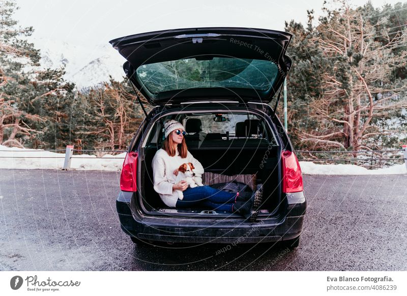 woman and cute jack russell dog enjoying outdoors at the mountain into the car. Travel concept. winter season snow travel lifestyle wanderlust traveling fun