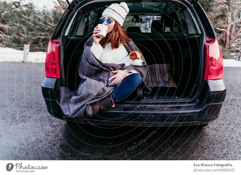 woman and cute jack russell dog enjoying outdoors at the mountain into the car. Travel concept. winter season snow travel lifestyle wanderlust traveling fun