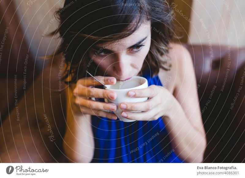 young beautiful woman enjoying a cup of coffee in a cafe. laptop besides. Casual blue dress. Modern life indoors morning holding beauty girl adult lovely joyful