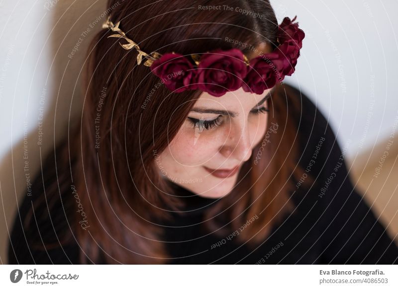 top view portrait of a young beautiful woman wearing a red roses wreath. She is smiling, indoors. Lifestyle head elegance amazing aroma care sexy model pretty