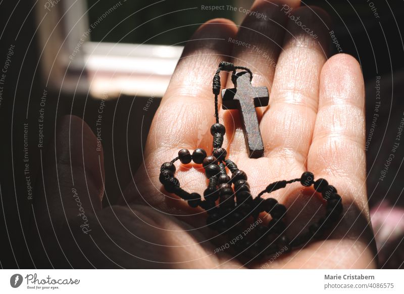 Holding a wooden crucifix symbolizing hope and the coming of Christ during the Lenten Season Catholic Faith Religious celebration spiritual concept