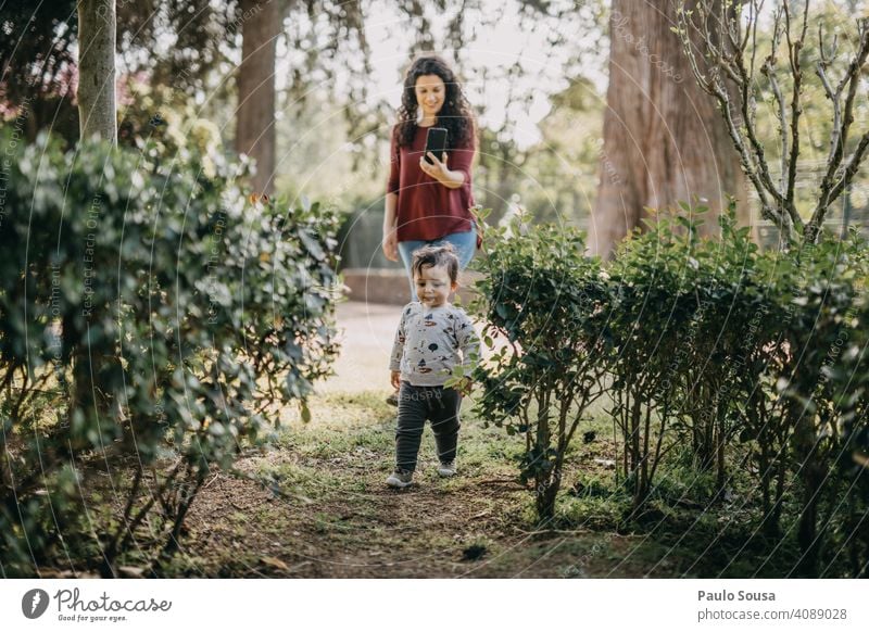 Mother photographing child playing  in the park Mother with child Child Caucasian 1 - 3 years Playing Park having fun Life Parents Love Together Joy Happy