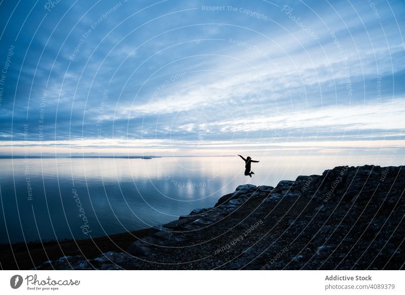 Happy man jumping on rocky coastline joy sea happy person joyful excited fun people wales happiness achievement energy active positive triumph freedom carefree