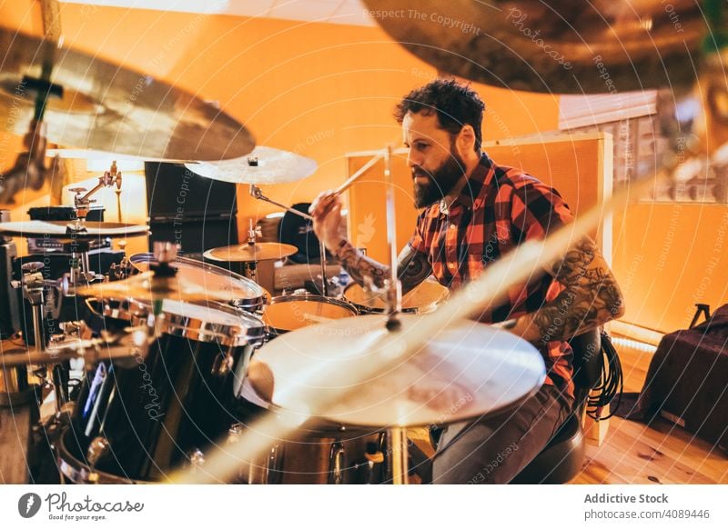 Musician playing drum man musician drummer instrument lifestyle sound concert drumsticks male artist song entertainment fun performance rock creative interior