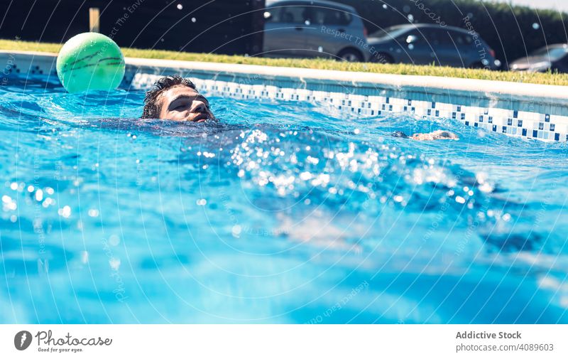 Man floating in swimming pool man posing water summer wet leisure vacation portrait human face swimmer looking out ripple surface summertime unemotional