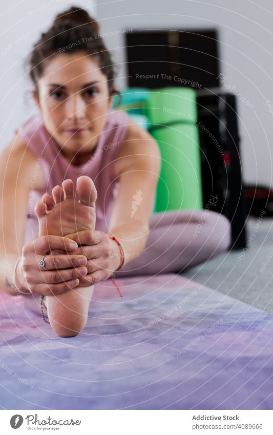 Attractive pensive woman doing yoga indoors concentrated practicing workout stretching attractive flexible sportive pose above head brunette young contemporary