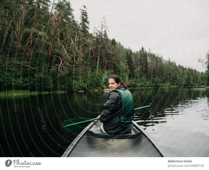 Woman boating on forest river in Finland woman travel lifestyle summer vacation oar life vest female young water fun people adventure tourism beautiful nature