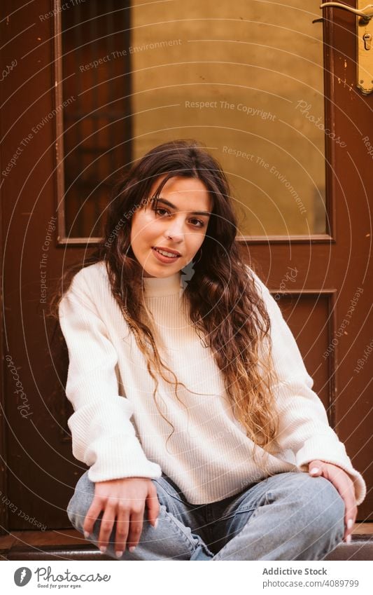 Cheerful young woman in street portrait park city border leaning smiling sunny daytime carefree lifestyle leisure female casual cheerful happy joy fence summer