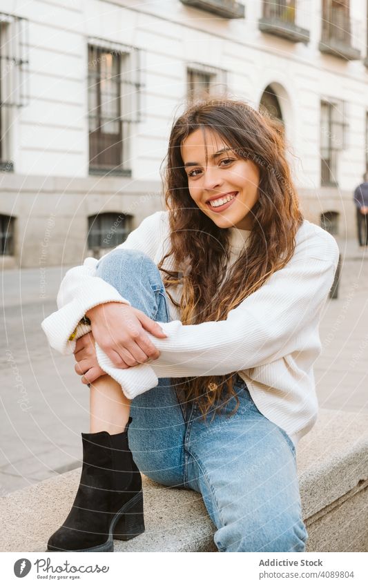 Cheerful young woman in street portrait park city border leaning smiling sunny daytime carefree lifestyle leisure female casual cheerful happy joy fence summer