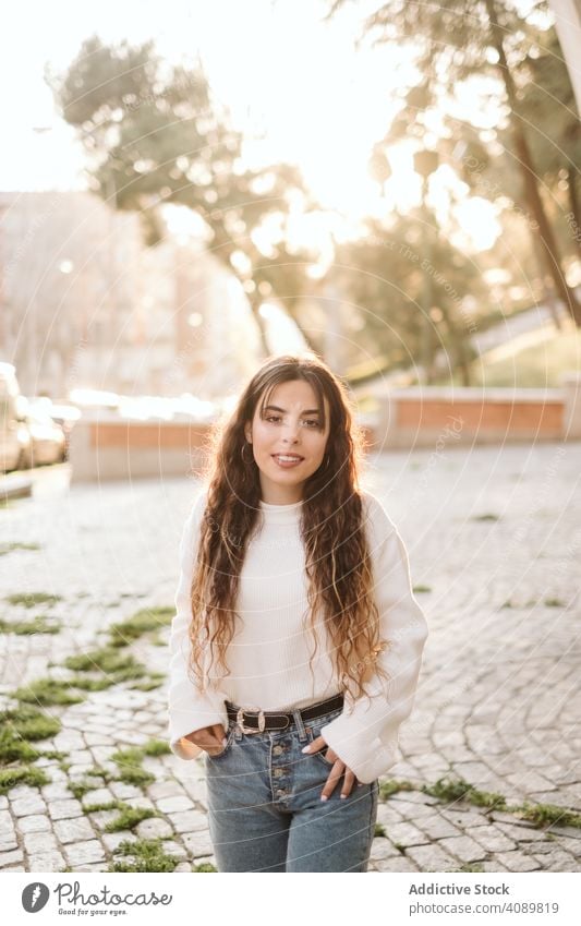 Cheerful young woman in street portrait park city border leaning smiling sunny daytime carefree lifestyle leisure female casual cheerful happy joy fence summer