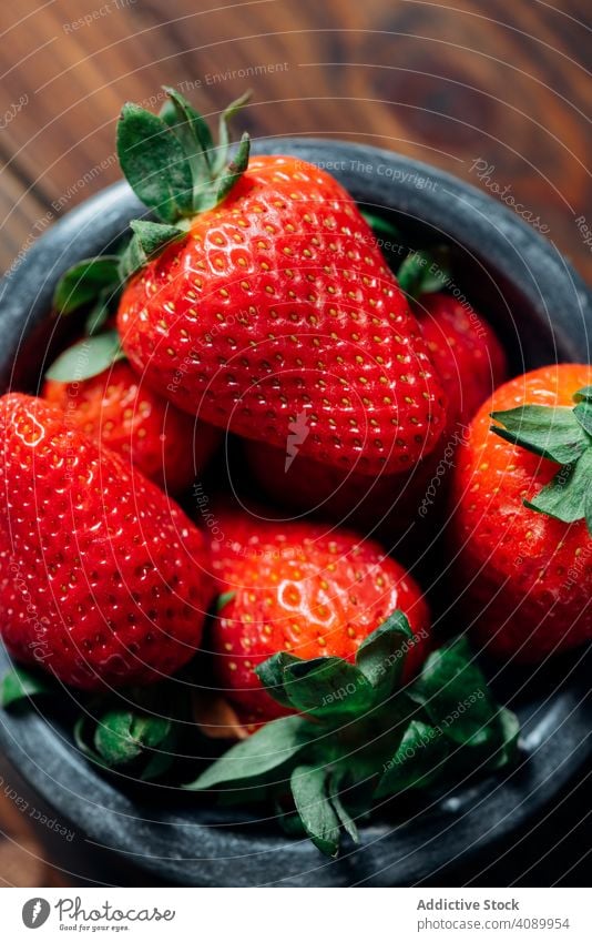 Fresh ripe strawberries in black concrete bowl. wood background juicy seasonal healthy breakfast organic above gourmet fruit spring fruity summer wooden closeup