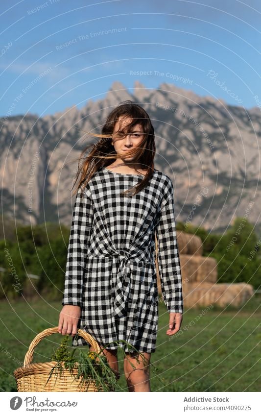 Portrait of teen girl with basket of herbs teenager farm back view anonymous carrying walking field catalonia spain anoia sunny daytime casual harvest lifestyle