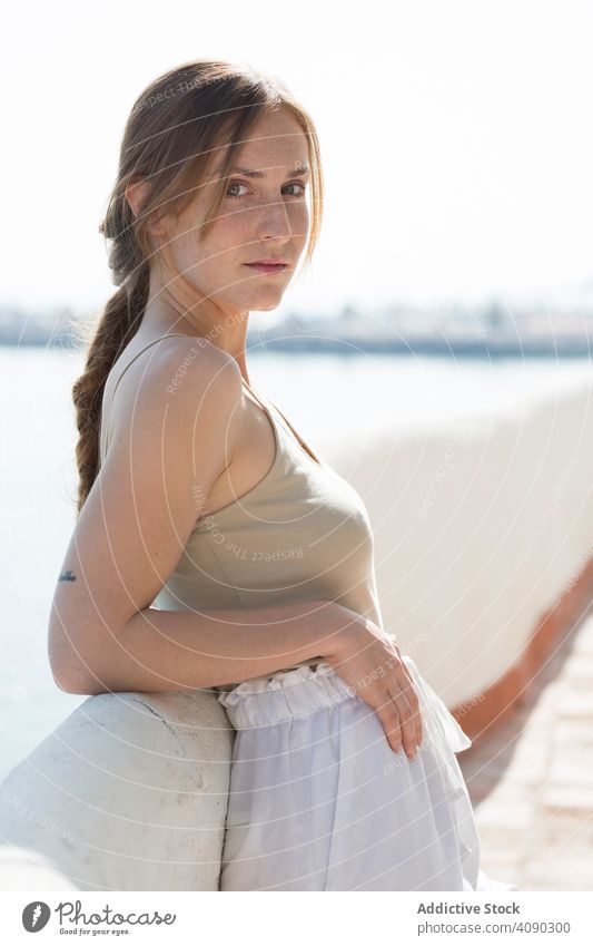 Sensual woman walking on embankment sea sensual dreamy sunny daytime female railing border thoughtful lifestyle leisure rest relax young city lady pavement