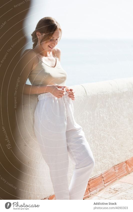 Sensual woman walking on embankment sea sensual dreamy sunny daytime female railing border thoughtful lifestyle leisure rest relax young city lady pavement